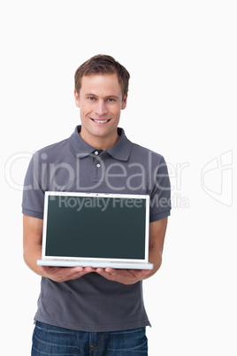 Smiling young man showing screen of his notebook