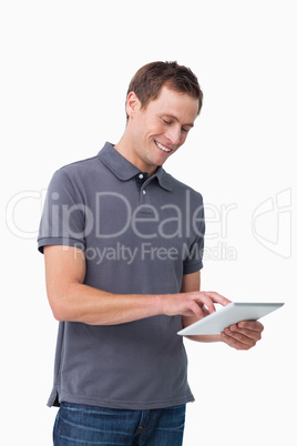 Smiling young man working on his tablet computer