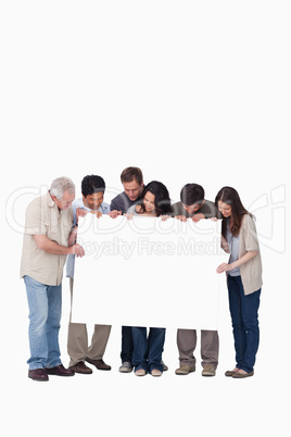 Group of friends holding blank sign together