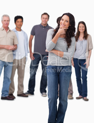 Woman in thinkers pose with friends behind her