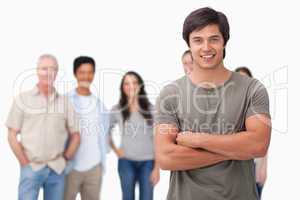 Young man with arms folded and friends behind him