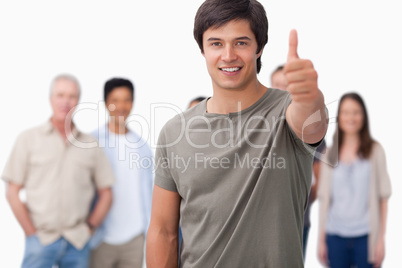 Smiling man with friends behind him giving approval