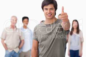 Smiling man with friends behind him giving approval