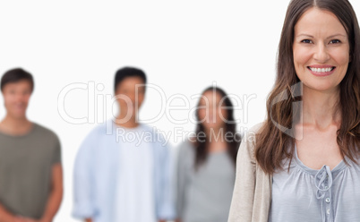 Smiling woman with her friends standing behind her