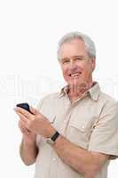 Smiling mature male typing a text message