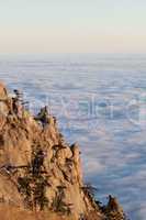 Sunlit cliffs and sea in clouds