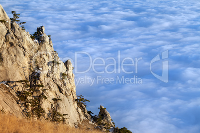 Sunlit cliffs and sea in clouds