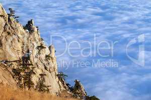 Sunlit cliffs and sea in clouds