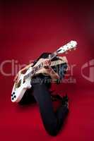 rock woman in black leather on red play guitar
