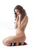 Young nude pregnant woman in color socks isolated