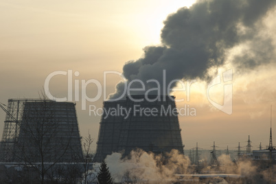 energy station with smoke at winter sunset
