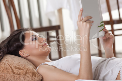 young woman lay in bed and read book