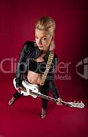 rock woman in black leather posing whit guitar