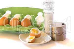 Hühnereier mit Eierbecher, Salzmühle und Eieruhr