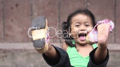 Happy little Asian girl smiling at camera and playingHappy little Asian girl smiling at camera and playing