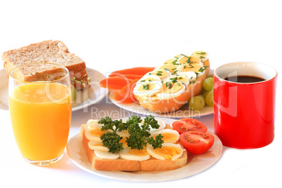 Frühstück mit Eierbrötchen, Kaffee und Orangensaft