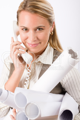 Young female engineer on phone carry blueprints