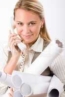 Young female engineer on phone carry blueprints