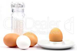 Drei Hühnereier mit Salzmühle und Eierbecher