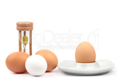 Hühnereier mit Eierbecher und Eieruhr