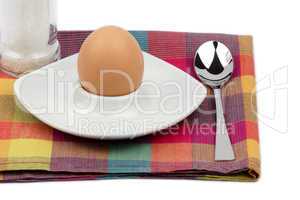 Frühstücksei im Eierbecher mit Salzmühle und Löffel
