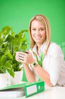 Green business woman in office smiling coffee