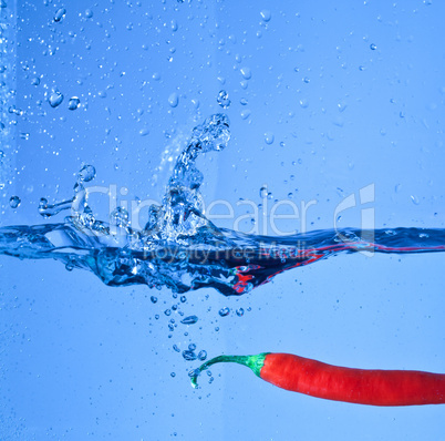 red pepper dropped into water with splash