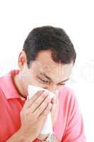 Young man with a cold blowing nose on tissue