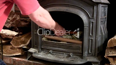 Building fire in wood stove; add kindling