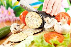 Woman's hands cutting aubergine eggplant