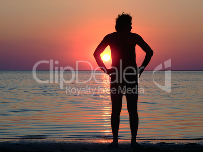 A black silhouette of a young guy on a sunset 1