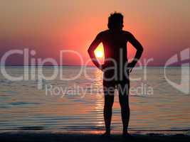 A black silhouette of a young guy on a sunset 1