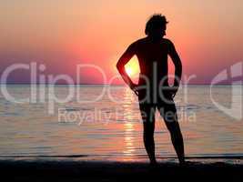 A black silhouette of a young guy on a sunset 2