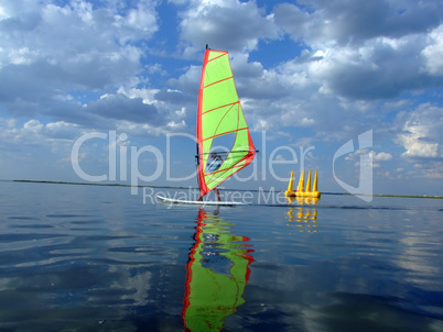 Windsurfer and its reflection in water of a gulf