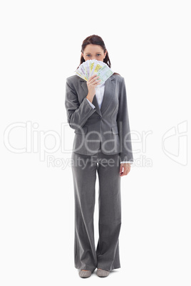 Businesswoman hiding with bank notes in her hand