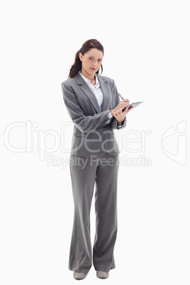 Businesswoman writing on a clipboard