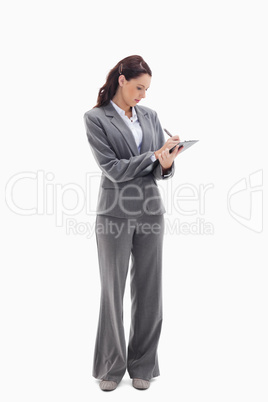 Businesswoman focusing and writing on a clipboard
