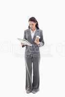 Businesswoman with a coffee reading a newspaper