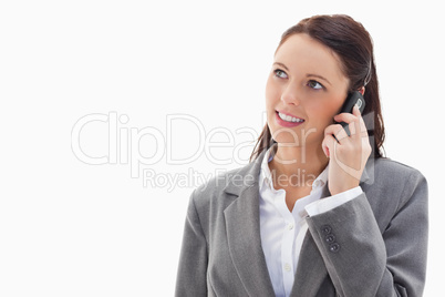 Close up of a businesswoman looking up while smiling on the phon
