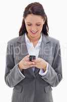 Businesswoman smiling and watching her phone