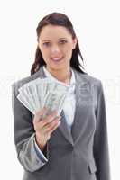 Close-up of a businesswoman smiling and holding a lot of dollar