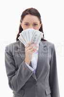 Businesswoman hiding behind a lot of dollar bank notes