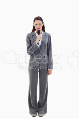 Serious businesswoman holding a microphone