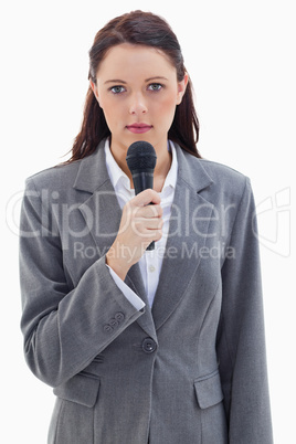 Close-up of a serious businesswoman holding a microphone