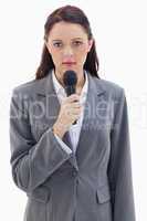 Close-up of a serious businesswoman holding a microphone