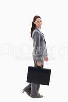 Profile of a business woman smiling and walking with a briefcase