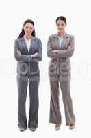 Two businesswomen smiling and crossing their arms