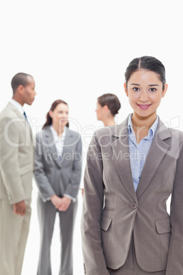 Businesswoman smiling with co-workers in the background