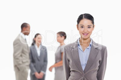 Businesswoman smiling with co-workers in the background