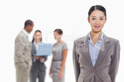 Businesswoman with co-workers watching a laptop in the backgroun